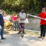 শারিরীক দূরত্ব রেখে লাঠির মাথায় বেঁধে খাদ্য সহায়তা দিচ্ছেন যুবলীগ নেতা