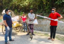 শারিরীক দূরত্ব রেখে লাঠির মাথায় বেঁধে খাদ্য সহায়তা দিচ্ছেন যুবলীগ নেতা