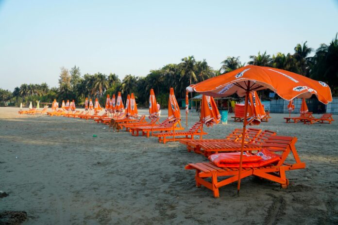 a row of chairs and umbrellas on the beach